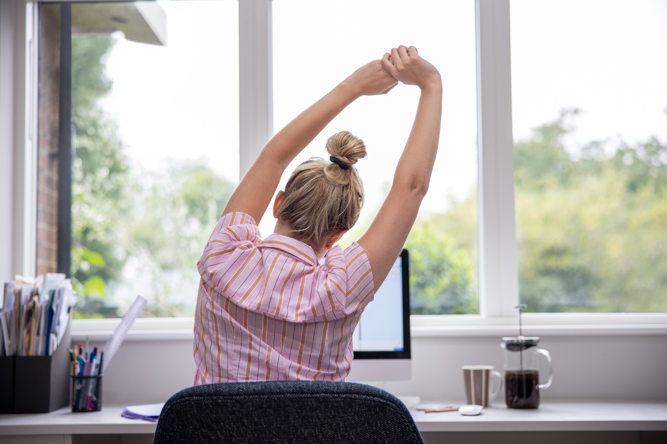 Woman taking a break to stretch at her desk